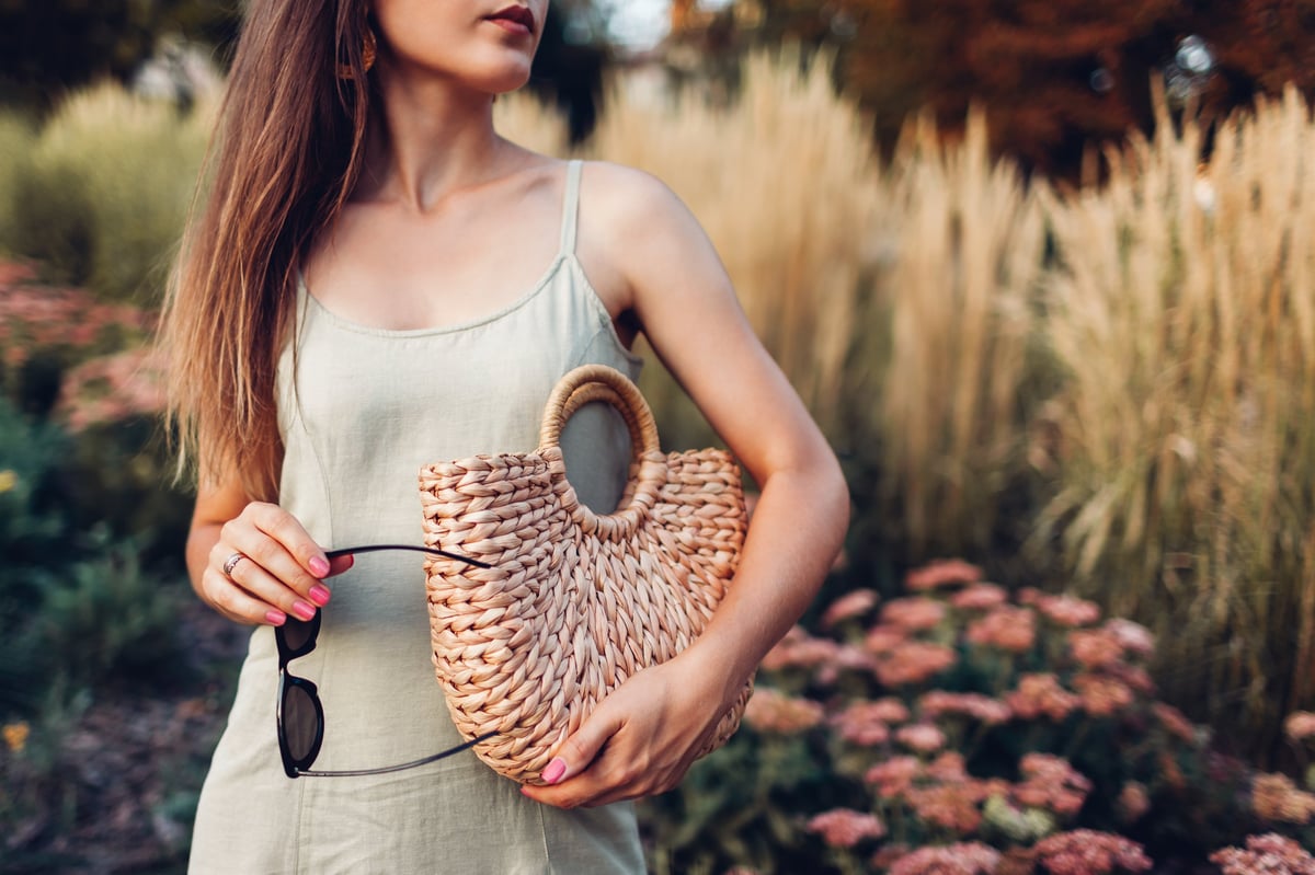 Woman in a summer linen dress with a straw bag